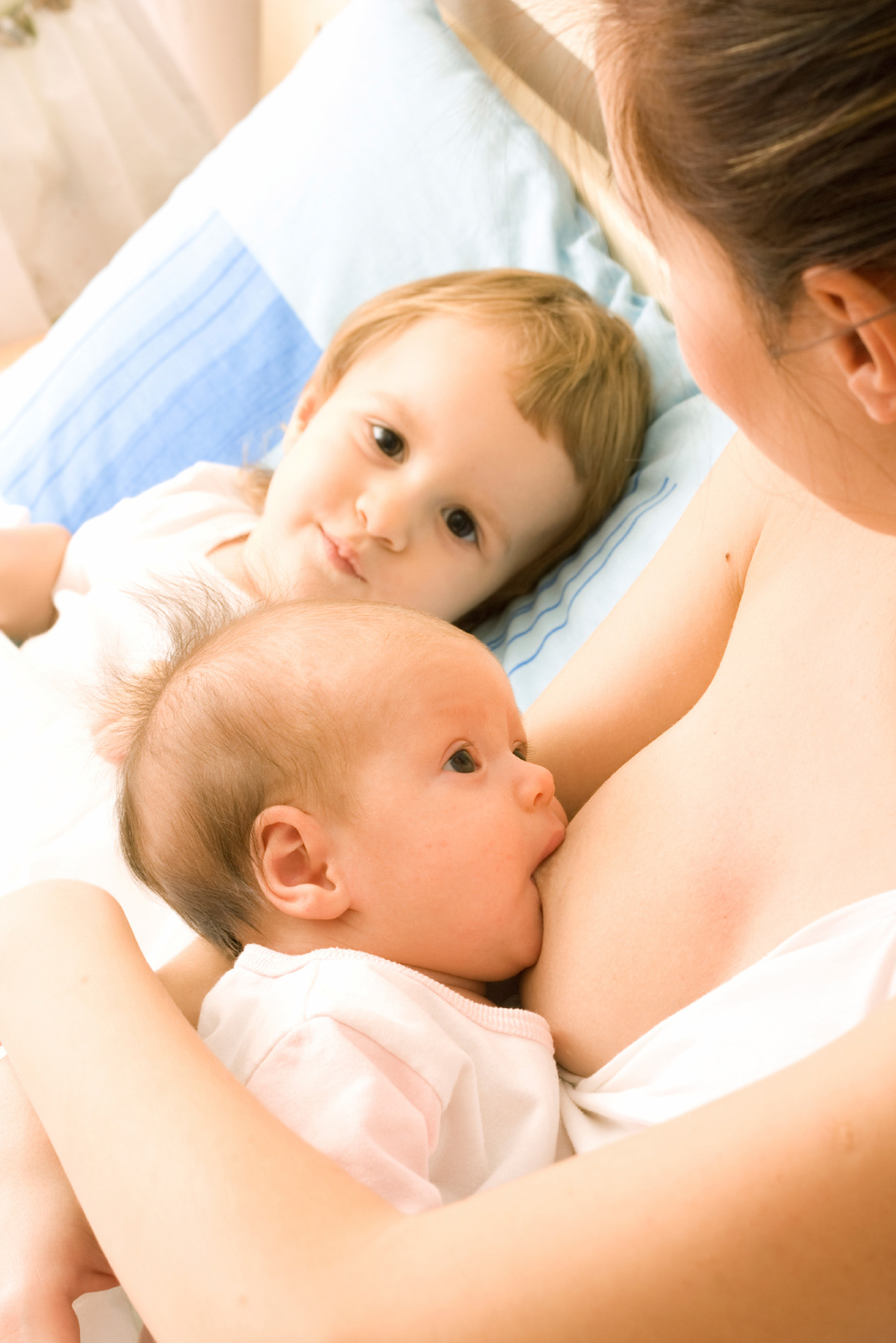 Mother with two daughters, breastfeeding baby